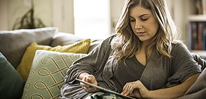 Woman Sitting on a Sofa Using a Table - NEA Discount Marketplace