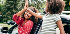 Mother and Daughter Giving a High Five From Their Car