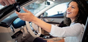 Car dealer is giving key for a new car to a woman