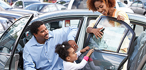 A family at a car dealership admiring a new car