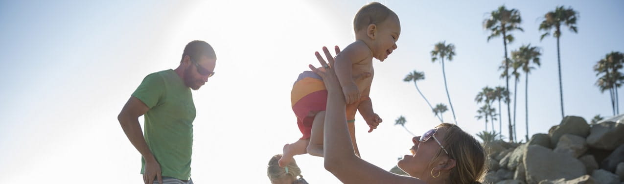 Young family plays on the beach