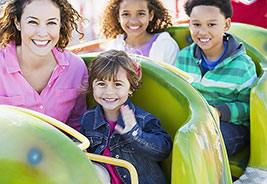 Adult Woman and Three Children on Amusement Park Ride - NEA Discount Ticket Program