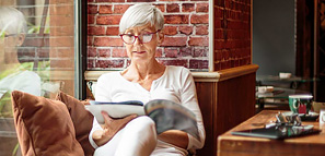 Woman Reading a Magazine While Relaxing in Coffee Shop