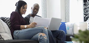 Personal Loan: Man and woman sitting on couch looking through papers