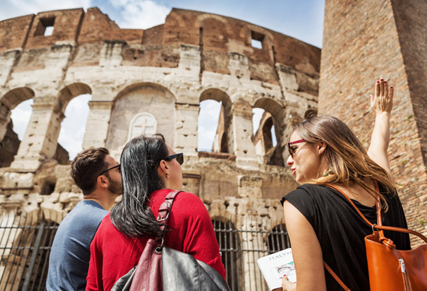 NEA Travel: Guided Tours - Tourists exploring the Coliseum of Rome with their knowledgeable guide.