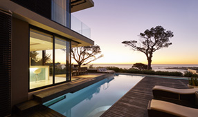 NEA Travel Hotels: Modern luxury room overlooking a swimming pool with sunset ocean view