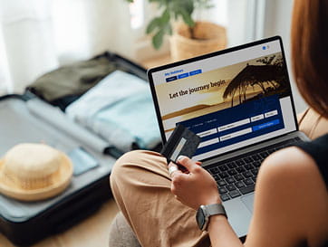 Young Woman Booking Vacation Online Via Laptop and Making Payment With a Credit Card