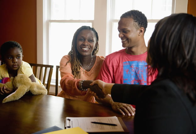Family at home signing papers with agent