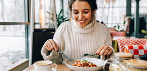 Young woman enjoying pasta lunch in restaurant