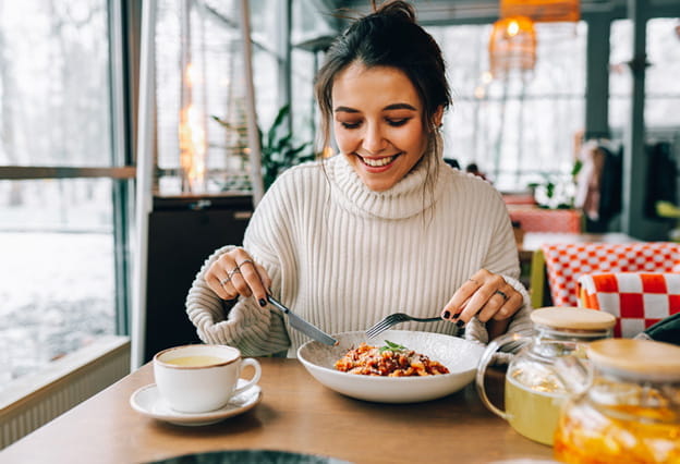 Young woman enjoying pasta lunch in restaurant