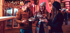 Friends eating donuts and having fun at an holiday fair