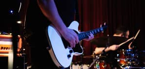 Guitarrista eléctrico con banda de rock and roll tocando música hard rock en el escenario