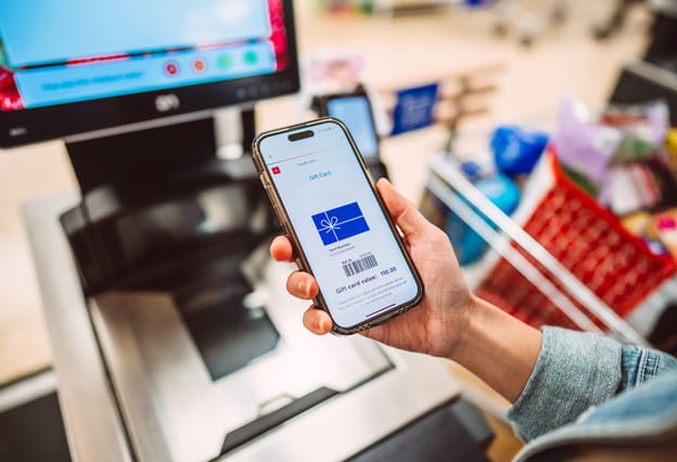 Customer holding a smart phone displaying a digital gift card