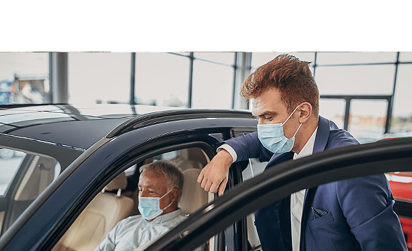 Car salesperson with protective face mask showing a car