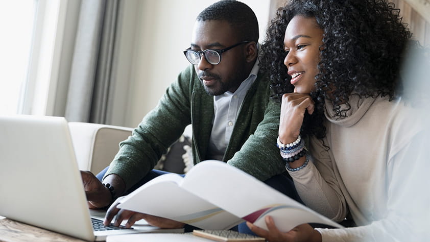 Pareja revisando información financiera en una computadora portátil