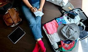 Una persona que hace un plan de viaje en el piso de la habitación del hotel