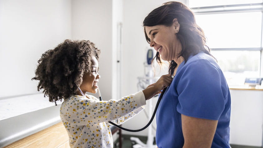 Young girl listening to nurse's heart with stethoscope