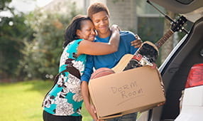 Madre ayudando a su hijo a empacar para la universidad