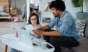 Pareja revisando sus finanzas y estrategias de pago de deudas, respaldada por beneficios y descuentos para miembros de SEIU.