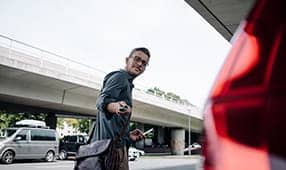 Joven usando el control remoto de la llave del auto para bloquear el auto