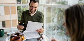 Couple reviewing finances during breakfast at home