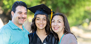 Parents smiling with their daughter after her college graduation
