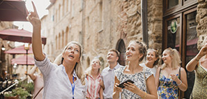 Group of people standing in a street listening to a tour guide