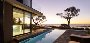 Moderna casa de lujo con patio y piscina con vista al mar al atardecer